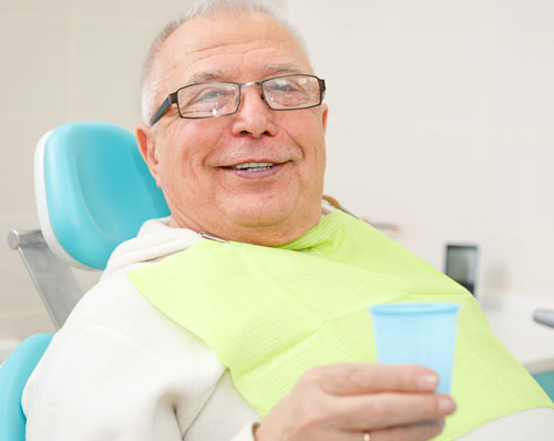 a man smiling after receiving dental implants from his dentist