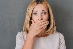 a patient at durham implant solutions covering her mouth