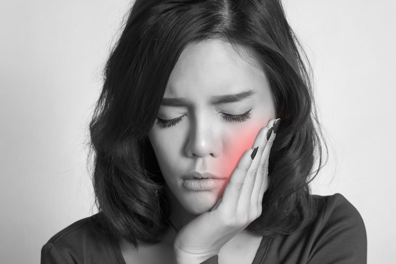 young women experiencing dental pain, black and white photo